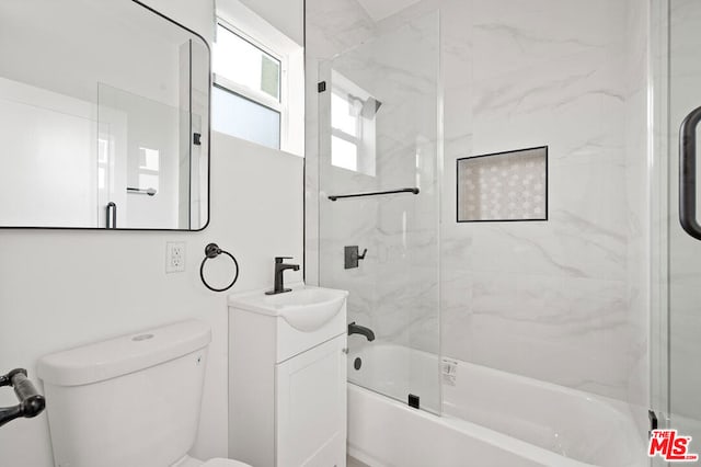 full bathroom featuring vanity, combined bath / shower with glass door, and toilet