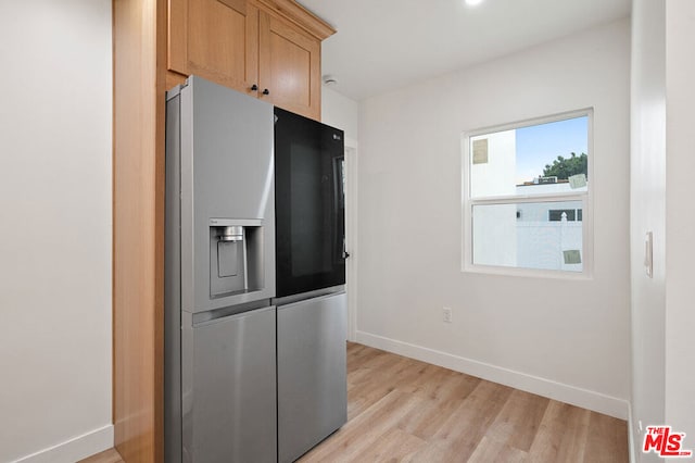 kitchen with stainless steel refrigerator with ice dispenser and light wood-type flooring