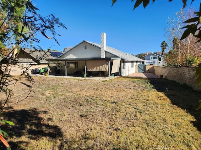 rear view of property with a patio and a lawn