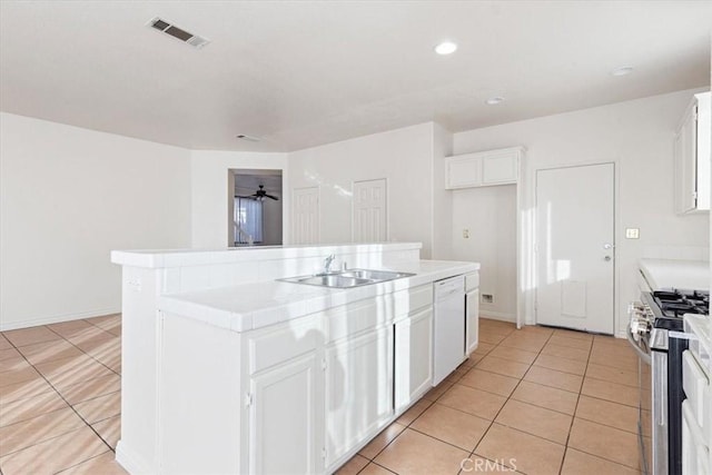 kitchen featuring a center island, sink, light tile patterned floors, gas stove, and white cabinetry