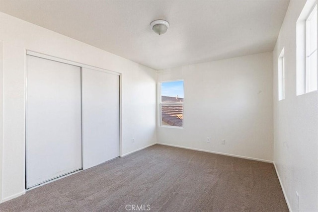 unfurnished bedroom featuring carpet flooring and a closet