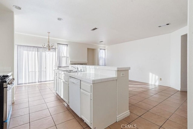 kitchen with white cabinets, gas range, sink, a center island with sink, and dishwasher