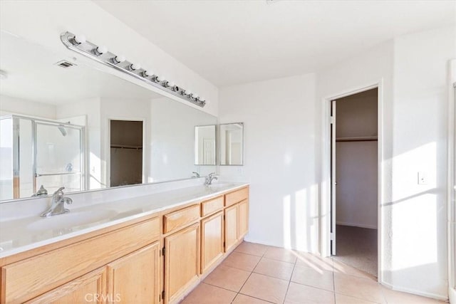 bathroom featuring tile patterned flooring, vanity, and walk in shower