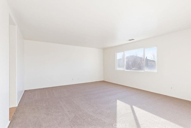 unfurnished room featuring light colored carpet