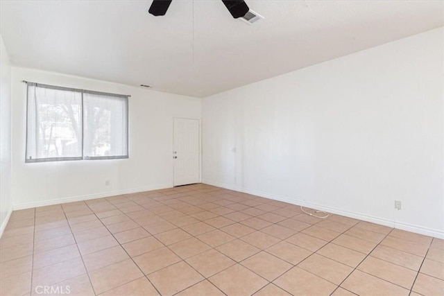 tiled spare room featuring ceiling fan