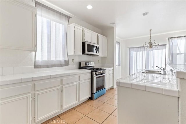 kitchen featuring stainless steel appliances, white cabinetry, and a healthy amount of sunlight