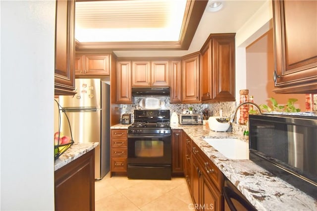 kitchen featuring sink, light stone counters, backsplash, light tile patterned floors, and black appliances