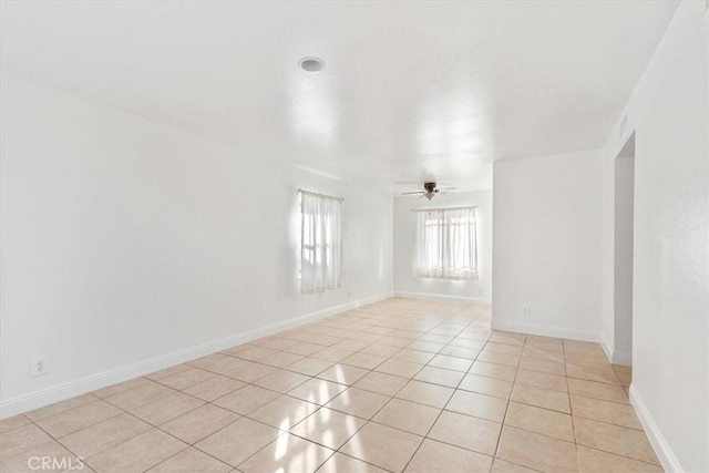 tiled spare room featuring ceiling fan