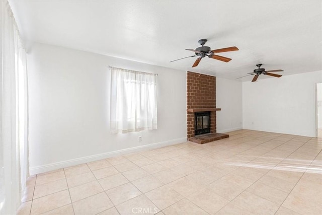 unfurnished living room with a fireplace, light tile patterned floors, and ceiling fan