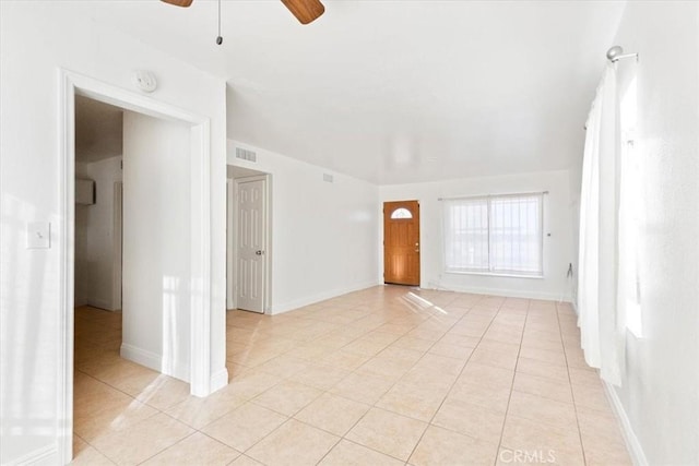 tiled spare room featuring ceiling fan