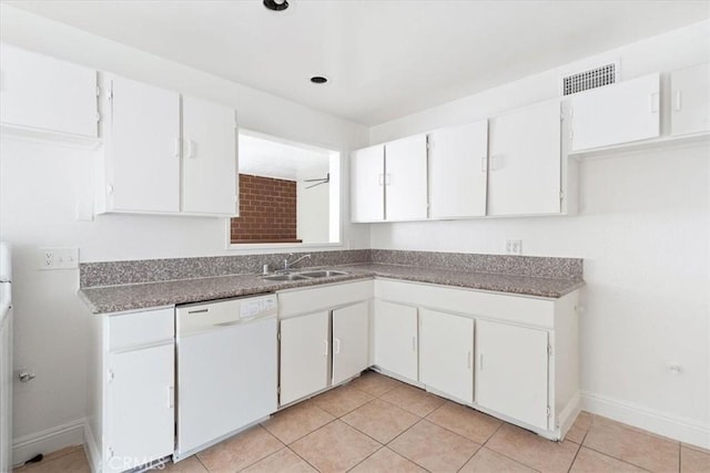 kitchen with white cabinets, light tile patterned floors, sink, and white dishwasher