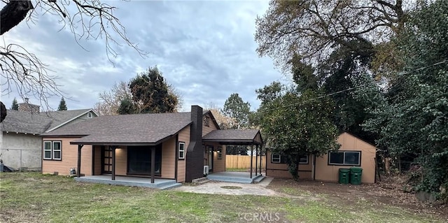 back of house featuring a patio and a lawn