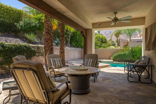 view of patio / terrace with ceiling fan and a fenced in pool