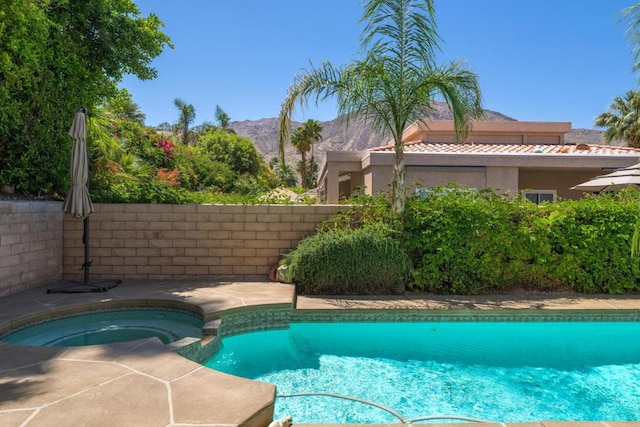 view of pool featuring an in ground hot tub and a mountain view