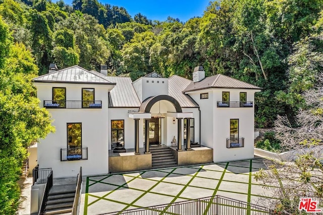 back of property with a balcony and a patio area