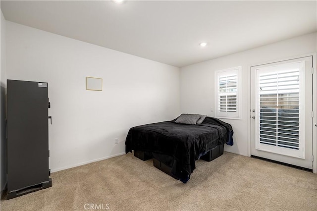 bedroom with access to exterior and light colored carpet