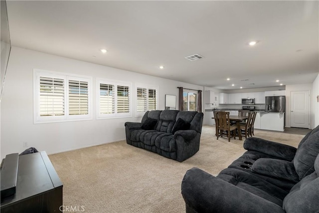 living room with a healthy amount of sunlight and light colored carpet