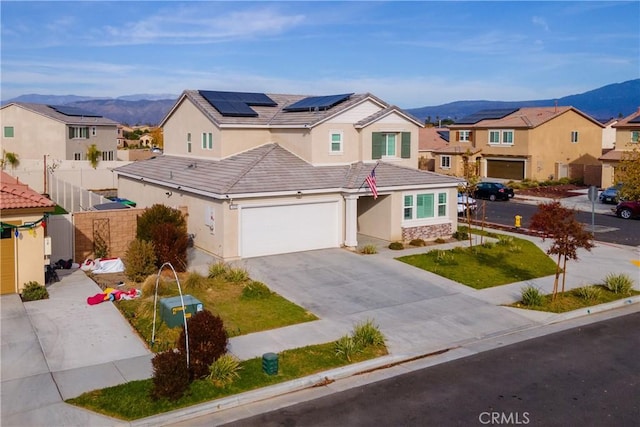 view of front of house featuring solar panels, a garage, and a mountain view