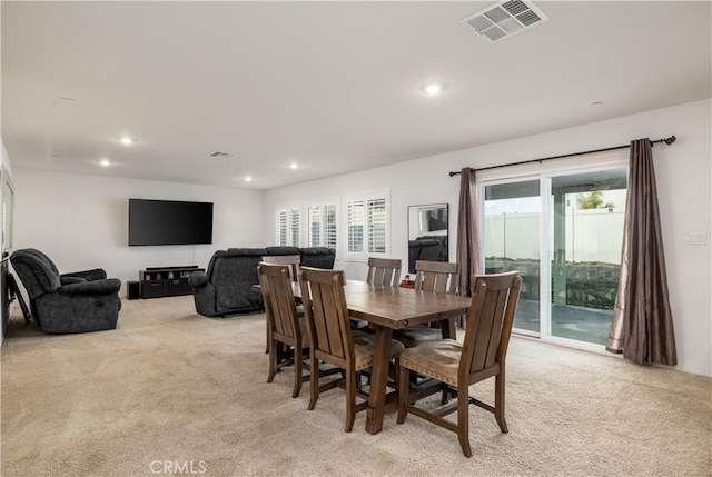 dining room with light colored carpet and a wealth of natural light