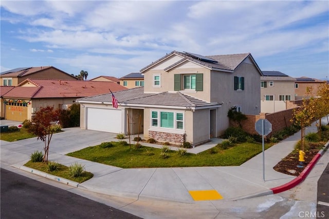 view of front of home with solar panels, a garage, and a front lawn