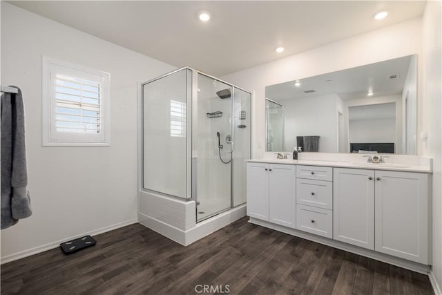 bathroom with walk in shower, vanity, and hardwood / wood-style flooring