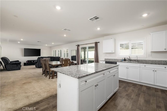 kitchen featuring a healthy amount of sunlight, white cabinetry, sink, and dark wood-type flooring