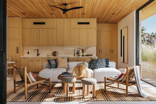 kitchen featuring ceiling fan, light brown cabinetry, wooden walls, and wooden ceiling