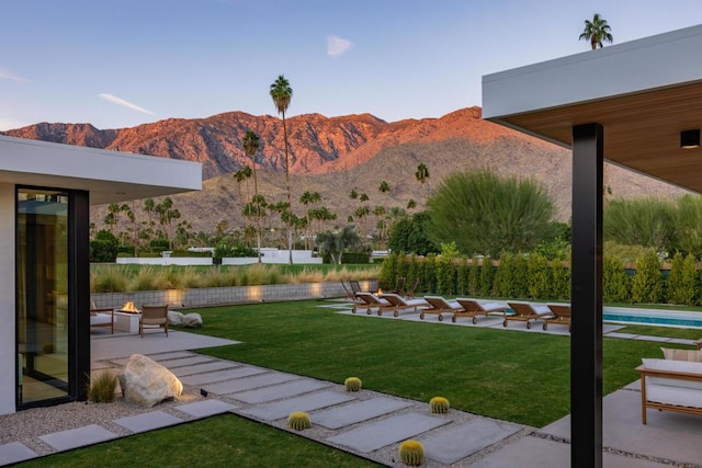 view of yard featuring a mountain view, a patio area, and a fire pit