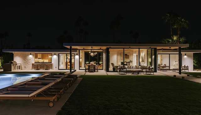 back house at twilight with a patio area, outdoor lounge area, and area for grilling