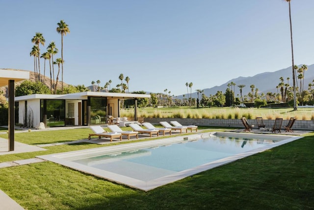 view of swimming pool featuring a mountain view and a yard