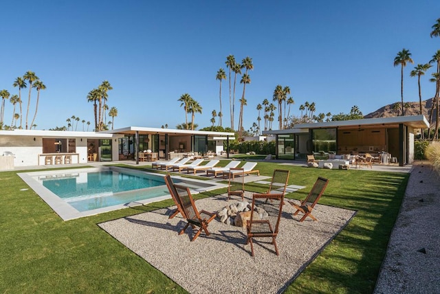 view of swimming pool with an outdoor bar, a yard, and a patio