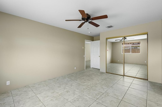 unfurnished bedroom with ceiling fan, a closet, and light tile patterned floors