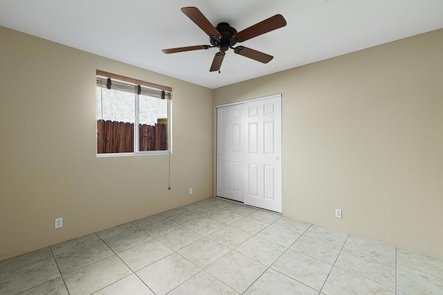 unfurnished bedroom featuring ceiling fan, a closet, and light tile patterned flooring