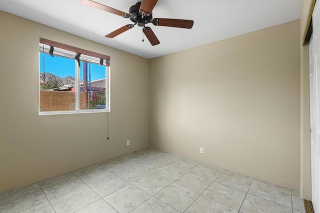 spare room with ceiling fan and light tile patterned flooring