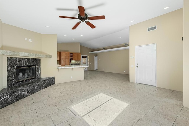 unfurnished living room with a premium fireplace, ceiling fan, light tile patterned flooring, and lofted ceiling