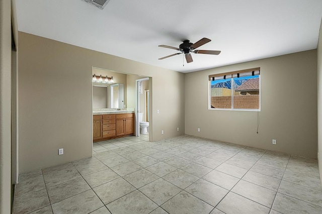 unfurnished bedroom with connected bathroom, ceiling fan, and light tile patterned flooring