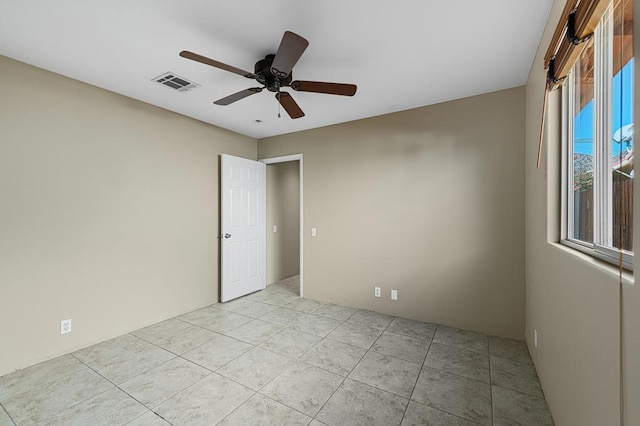 empty room featuring light tile patterned floors and ceiling fan