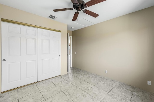 unfurnished bedroom with ceiling fan, a closet, and light tile patterned floors