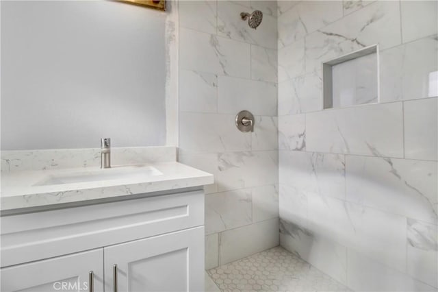 bathroom with vanity and tiled shower