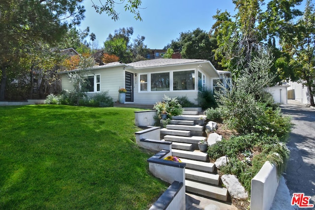 view of front of house with an outbuilding, a front yard, and a garage