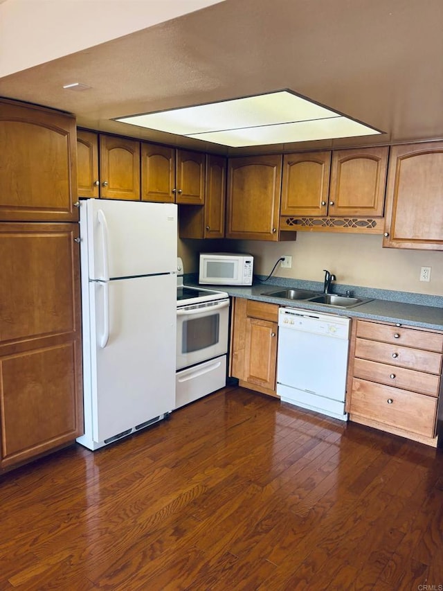 kitchen with dark hardwood / wood-style floors, white appliances, and sink