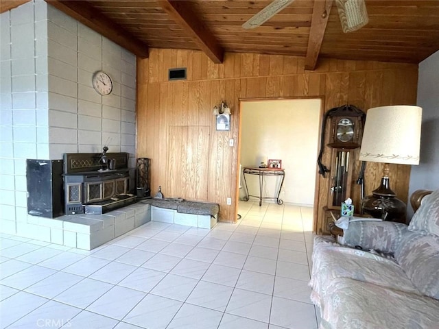 tiled living room with lofted ceiling with beams, wooden walls, a wood stove, and wooden ceiling