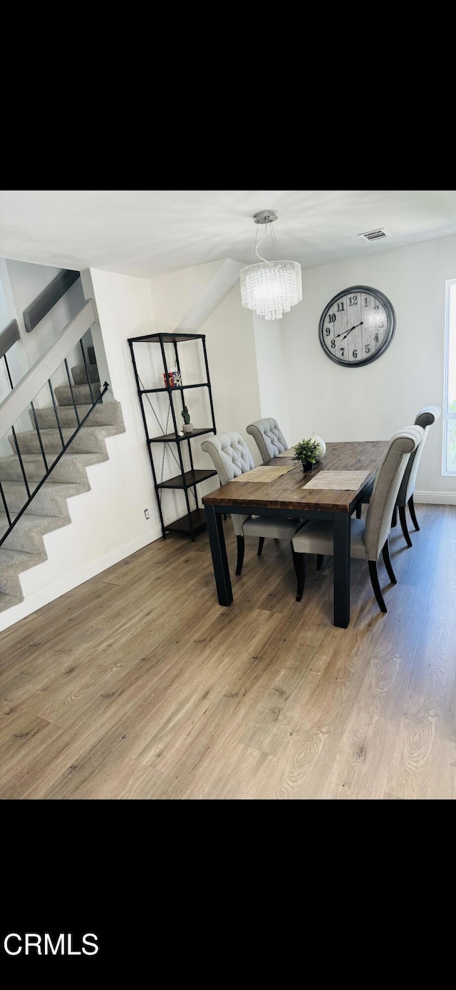 dining room featuring light hardwood / wood-style floors and a notable chandelier