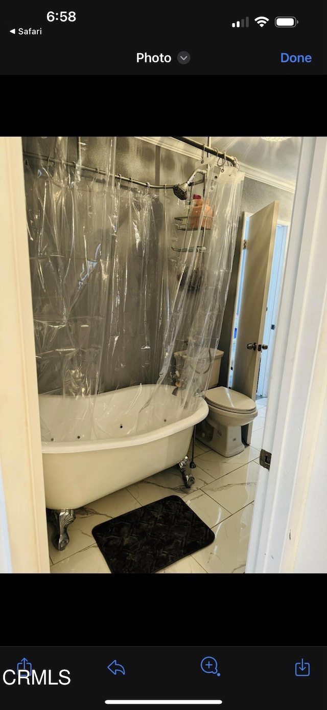 bathroom with toilet and shower / tub combo with curtain