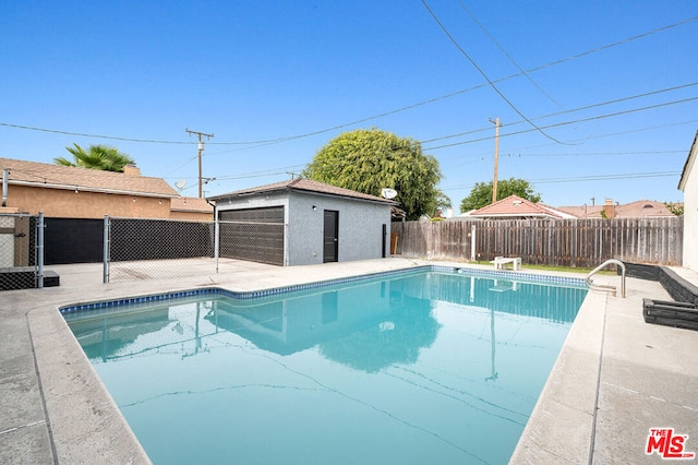 view of pool featuring an outdoor structure and a garage