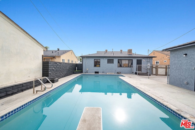 view of pool featuring a diving board and a patio