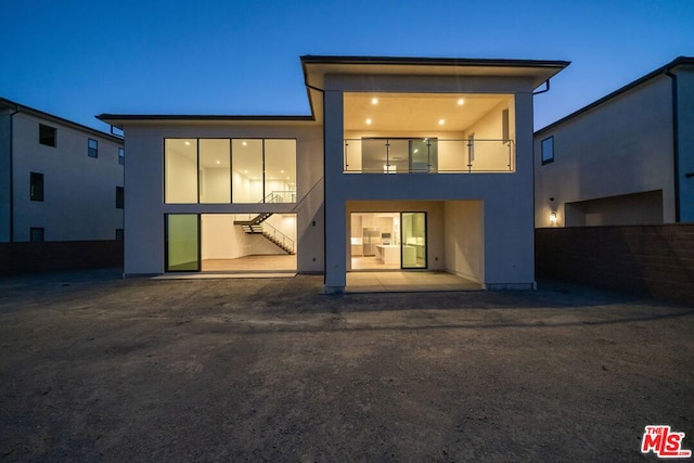 back of property featuring a balcony and a patio