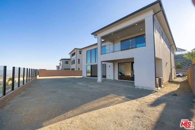 rear view of house with cooling unit and a patio