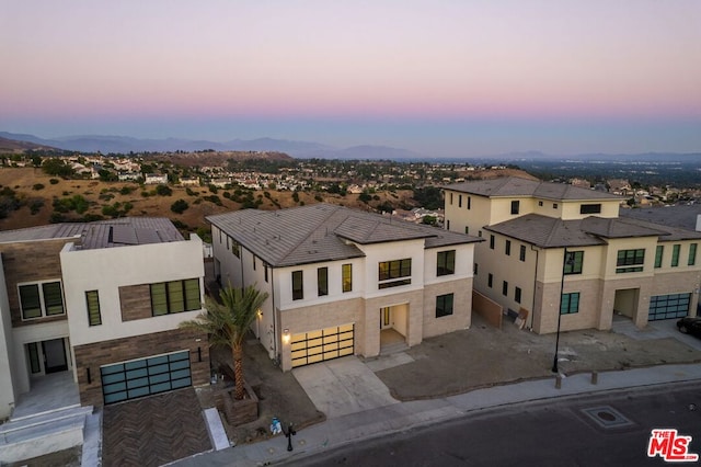 aerial view at dusk featuring a mountain view