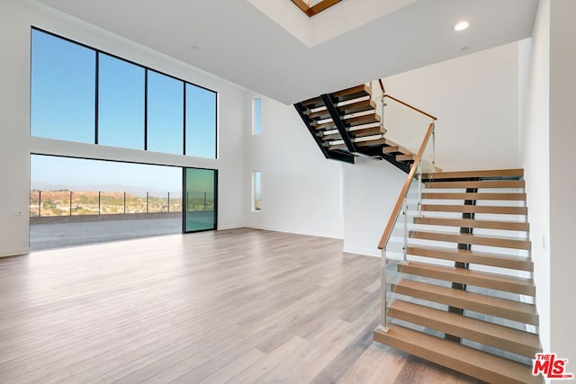 unfurnished living room with a high ceiling and light hardwood / wood-style flooring